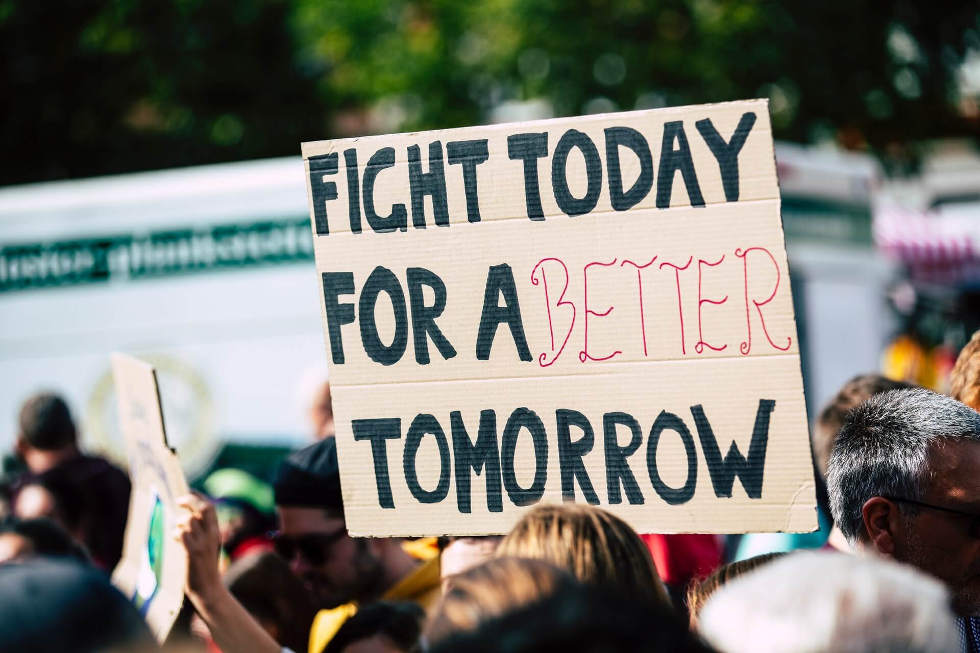 Person holding sign "Fight today for a better tomorrow"